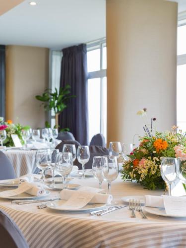 a long table with wine glasses and flowers on it at Sercotel Hotel Parque in Las Palmas de Gran Canaria