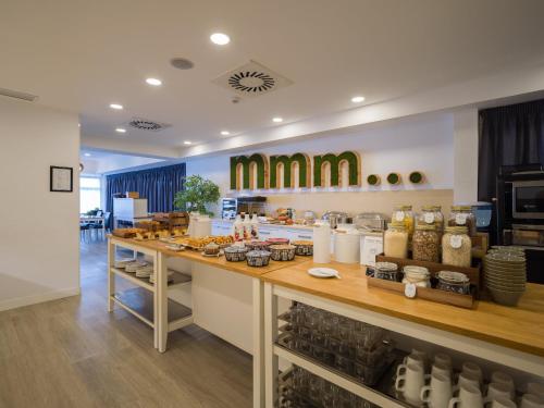 a restaurant with a counter with food on it at Sercotel Hotel Parque in Las Palmas de Gran Canaria