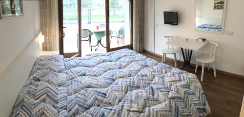 a large bed in a room with a table and chairs at Casa Vittoria in Nago-Torbole