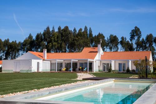 a house with a swimming pool in front of it at Casas da Lupa in Zambujeira do Mar