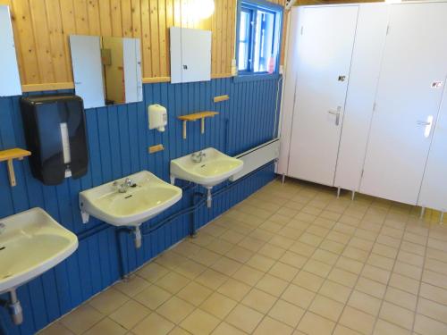 a bathroom with three sinks in a room at Hov Hyttegrend in Viksdalen