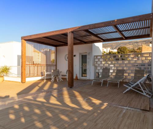 a patio with chairs and a wooden deck at Alpujarra Secret by eme hoteles in Órgiva
