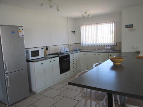 a kitchen with a table and a refrigerator at Point Village Accommodation - Hennie Top in Mossel Bay