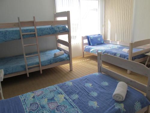 a room with three bunk beds and a window at Point Village Accommodation - Hennie Top in Mossel Bay