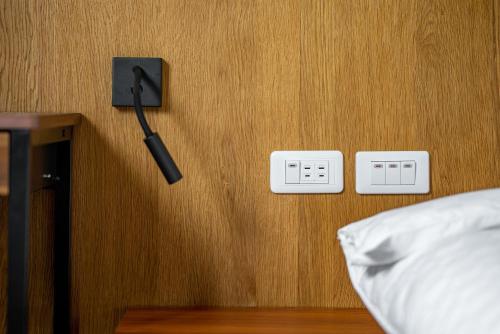 a bedroom with a bed and two electrical outlets at Penghu Storyteller in Magong