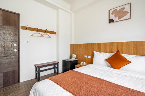 a bedroom with a bed and a wooden headboard at Penghu Storyteller in Magong