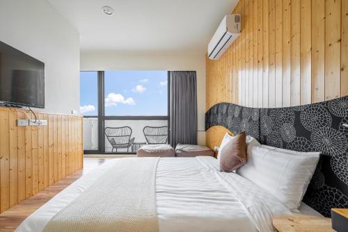a bedroom with a large bed and a television at Penghu Storyteller in Magong