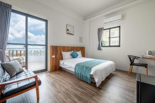 a bedroom with a bed and a large window at Penghu Storyteller in Magong