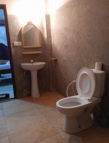 a bathroom with a toilet and a sink at Chapel Home Stay in Ahungalla