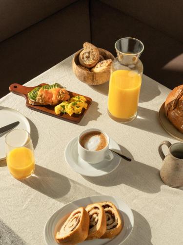 a table topped with plates of breakfast food and orange juice at Gästehaus Freitag das kleine Hotel in Sankt Georgen