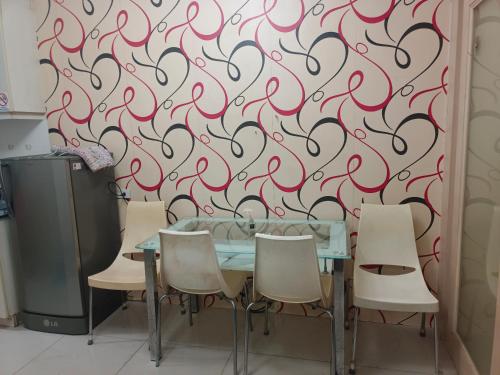 a dining room table with chairs and a red swirl wallpaper at Sea Residence Tower EF in Manila