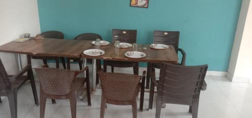 a wooden table and chairs with plates and bowls on it at Ranthambore Bagh niwas in Sawāi Mādhopur