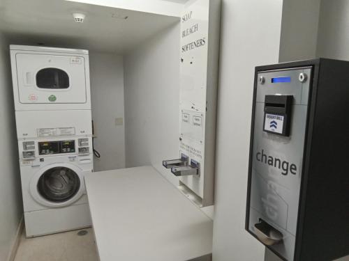 a laundry room with a washing machine and a washer at Holiday Inn Express Maspeth by IHG in Queens