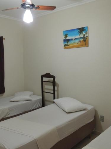 a bedroom with two beds and a ceiling fan at Hotel & Hostel San José in Ribeirão Preto