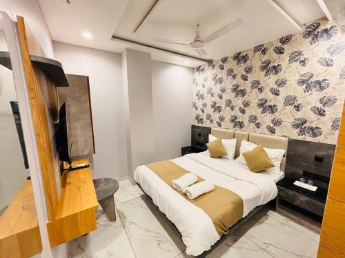 a bedroom with a bed and a tv in a room at Hotel Sparsh Inn in Ahmedabad