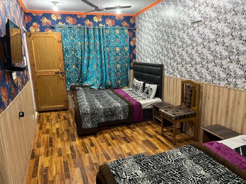 a room with two beds and a window with curtains at kaaka in Srinagar