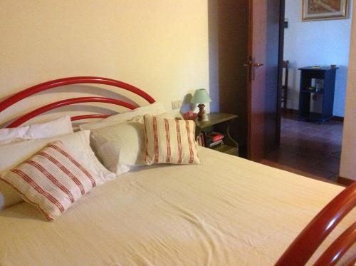 a bedroom with a bed with white sheets and pillows at Casa Vacanza La Ginestra Paciano in Paciano