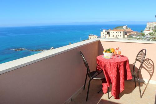 a table on a balcony with a view of the ocean at Hotel Terrazzo Sul Mare in Tropea