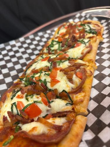 a slice of pizza on a plate on a table at Holiday Inn Montreal Longueuil by IHG in Longueuil