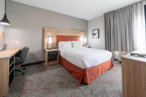a hotel room with a bed and a desk at Candlewood Suites Baytown by IHG in Baytown