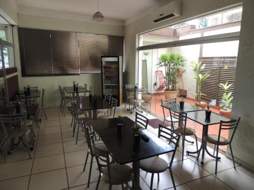 a dining room with tables and chairs in a restaurant at Hotel & Hostel San José in Ribeirão Preto