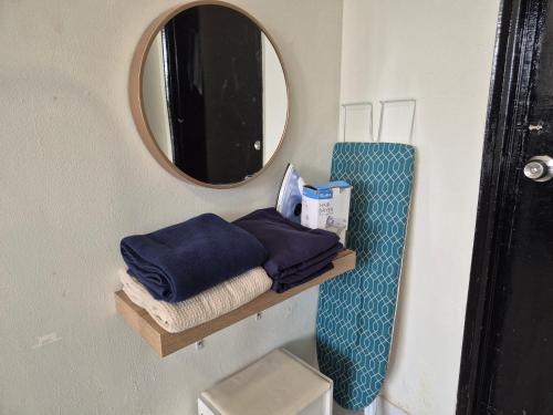 a bathroom with a mirror and towels on a shelf at 1-10pax DoorStep private beach & swimming pool in Port Dickson