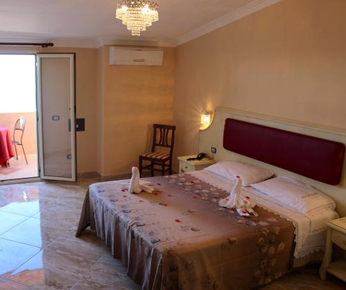 una camera da letto con un grande letto con fiori di Hotel Terrazzo Sul Mare a Tropea