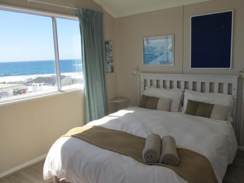 a bedroom with a bed with a view of the ocean at Point Village Accommodation - Laurie's House in Mossel Bay