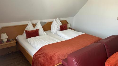 a bedroom with a large bed with white and red pillows at Gästehaus Freitag das kleine Hotel in Sankt Georgen