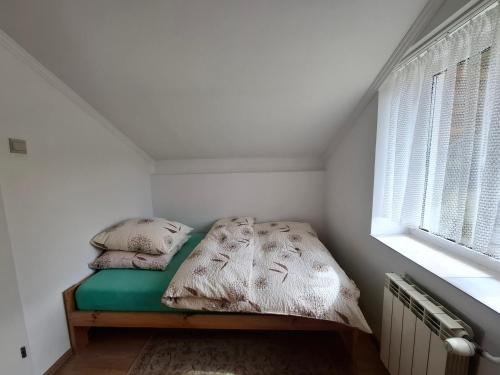 a small bed in a room with a window at Pod akacjami in Baligród
