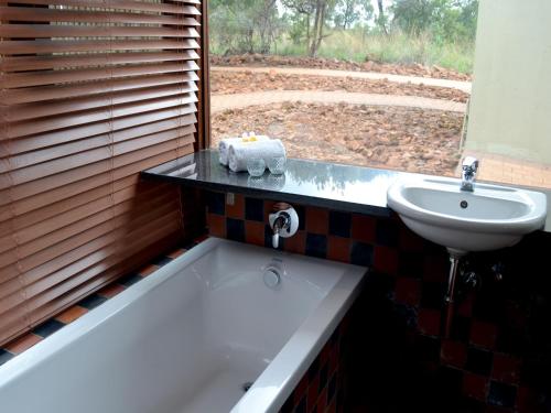 a bathroom with a bath tub and a sink at Elements Private Golf Reserve in Bela-Bela
