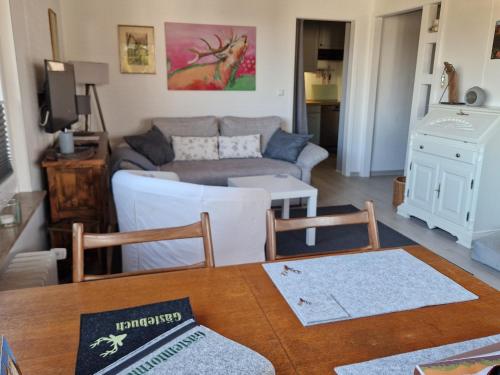 a living room with a couch and a table at Ferienwohnung Tannenhöhe direkt am Wald in Schulenberg im Oberharz