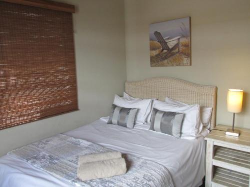 a bedroom with a bed with white sheets and pillows at Point Village Accommodation -Linky's House in Mossel Bay