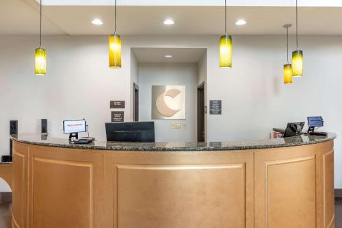 a lobby with a large wooden bar with lights at Comfort Suites Manhattan in Manhattan