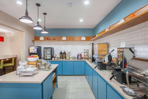 a large kitchen with blue cabinets and blue counters at Country Inn & Suites by Radisson, Lewisville, TX in Lewisville