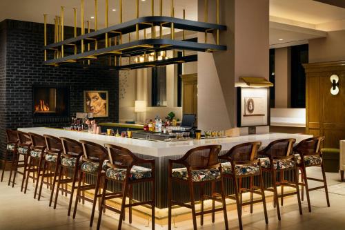 a bar with a bunch of chairs around it at Tempo By Hilton Raleigh Downtown in Raleigh