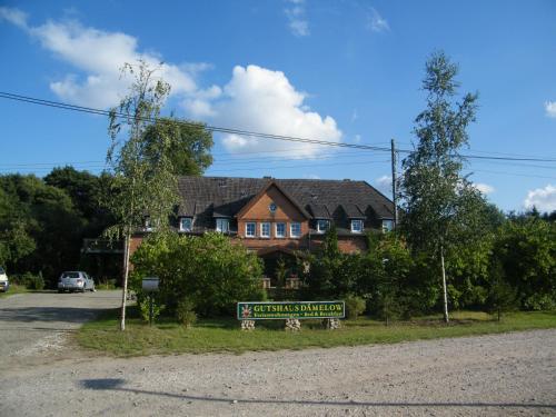 ein Haus mit einem Schild davor in der Unterkunft Gutshaus Dämelow Wismar in Dämelow