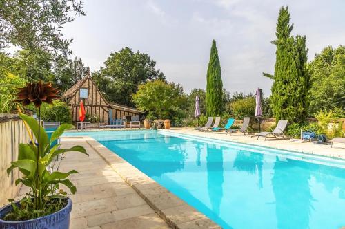une piscine avec des chaises et une maison dans l'établissement Charme Rustique, Colombier, Cottage et Piscine, à Saint-Laurent-des-Hommes