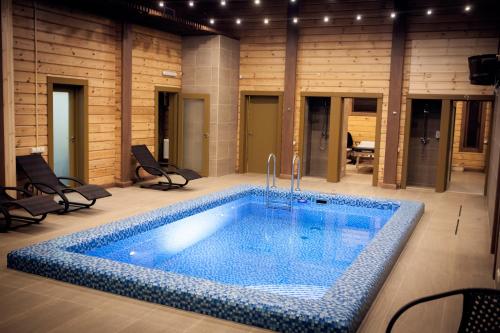 una gran piscina en una habitación con sillas en Country Club Aivengo Hotel Jungle, en Podolsk