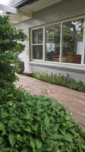a porch of a house with a bunch of plants at Cherrywood-luxe retreat in the Southern Highlands in Exeter
