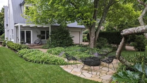 a yard with chairs and a house at Cherrywood-luxe retreat in the Southern Highlands in Exeter