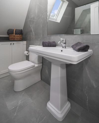 a bathroom with a white sink and a toilet at Cherrywood-luxe retreat in the Southern Highlands in Exeter