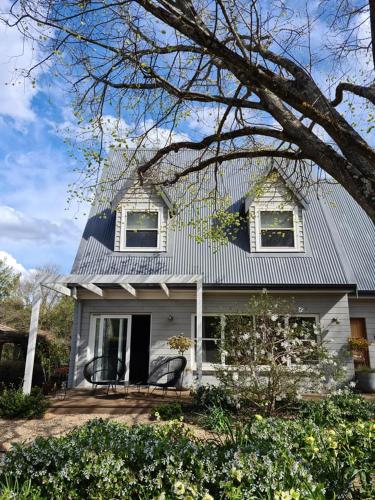 a white house with two chairs on the porch at Cherrywood-luxe retreat in the Southern Highlands in Exeter
