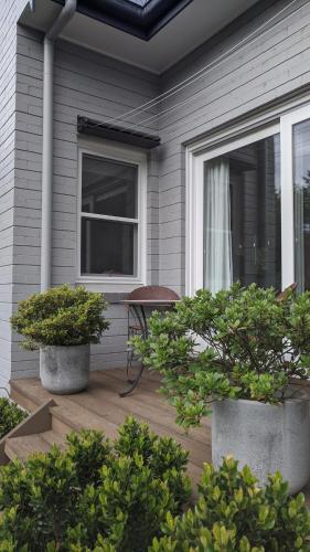 a porch with two potted trees on a house at Cherrywood-luxe retreat in the Southern Highlands in Exeter