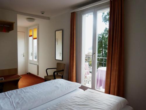 Tempat tidur dalam kamar di Hotel Rigi Vitznau