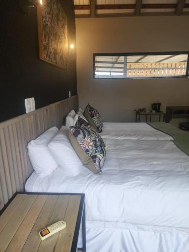 a white bed with a remote control on top of it at eKhaya Bush Lodge in Hoedspruit