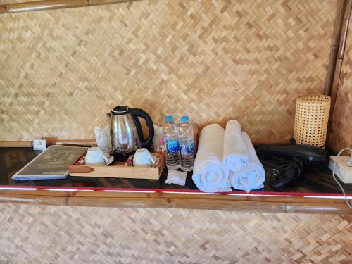 a shelf with a tea kettle and bottles of water at Rice Wonder Cafe & Eco Resort in Rayong