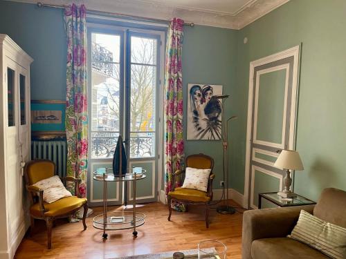 un salon avec un canapé et une fenêtre dans l'établissement AME Mombrun, à Vichy