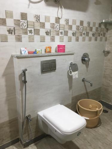 a bathroom with a white toilet and a shower at Family Friendly Guest House in Bengaluru