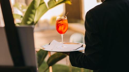 a person holding a plate with a drink on it at InterContinental Porto - Palacio das Cardosas by IHG in Porto